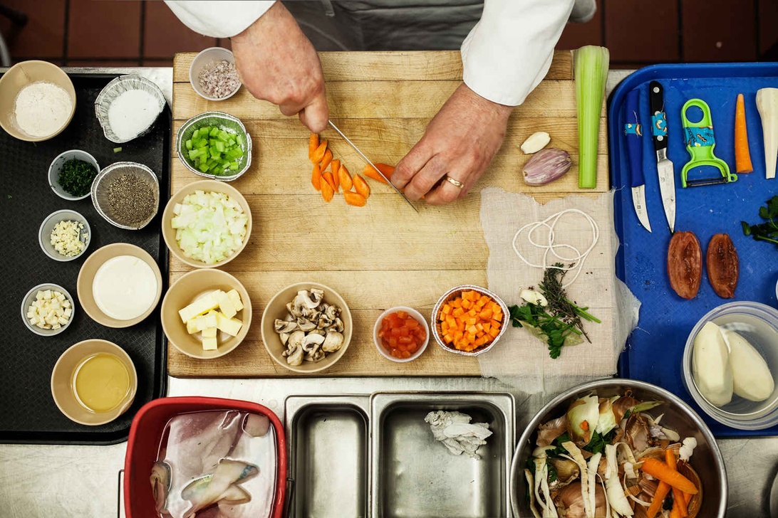 Noggrant förberedda ingredienser för matlagning på en skärbräda med diverse skålar runtomkring.